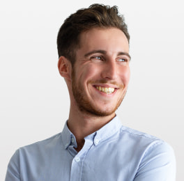 smiling man with brown hair wearing a blue shirt