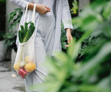 woman carrying a bag of fruits and vegetables