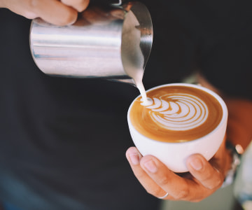 person decorating a coffee