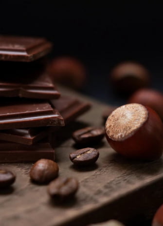 chocolate fragments with hazelnuts and grains of coffie lying on the table
