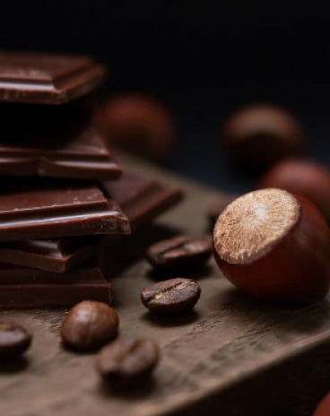 chocolate fragments with hazelnuts and grains of coffie lying on the table